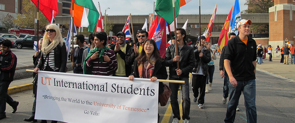 Ihouse students at an event with a banner