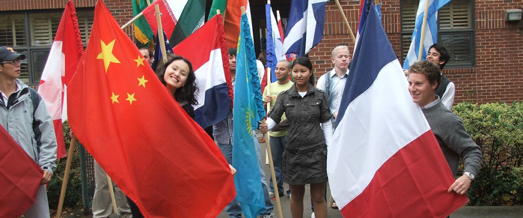 Students holding flags from different countries